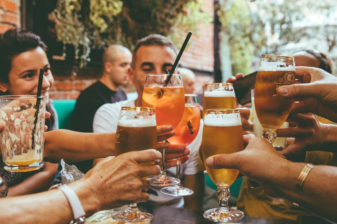 Un groupe de professionnels souriants, verres à la main, lors d'un apéro pro léger en France, avec des options de boissons et de nourriture saines.
