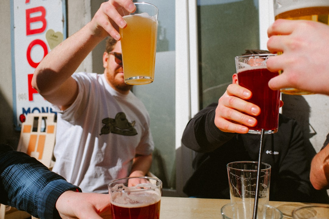 Verre de bière légère La Deux Cinq, fraîche et sans sucres, sur fond de paysage belge, symbolisant la buvabilité.